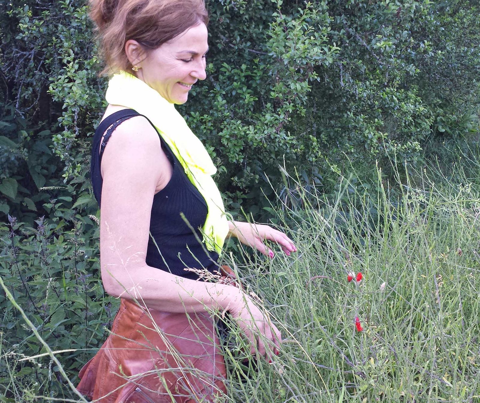 Nisha Stein geht durch eine hohe Sommerwiese